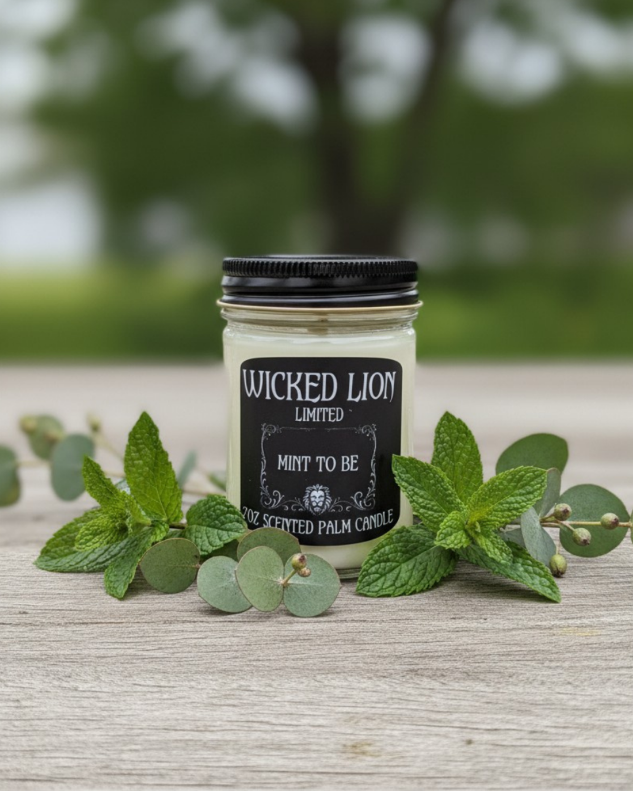 Candle jar labeled 'Wicked Lion' with mint leaves on a wooden surface